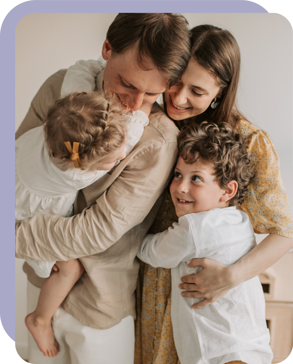 Une famille avec deux enfants s’embrasse.
