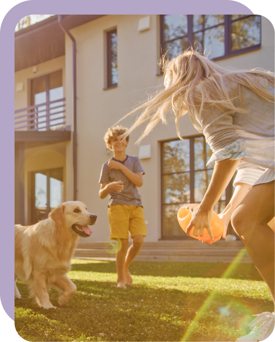 Une femme joue avec son fils et son chien dans le jardin.