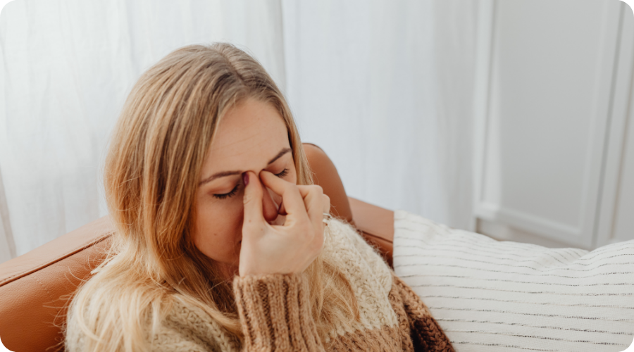 La femme se tient les sinus.